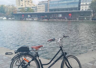 Vélo électrique avec vue sur la Seine et le centre commercial, design robuste pour balades urbaines, proche de l'artisanat Atelier Robuste.