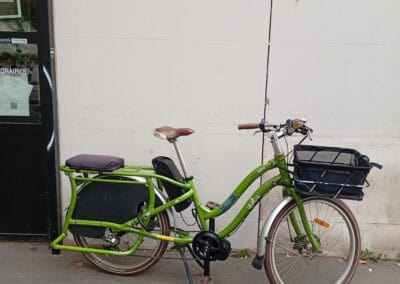 Vélo électrique Vert avec panier pour livraison, alliant durabilité et praticité à Atelier Robuste.